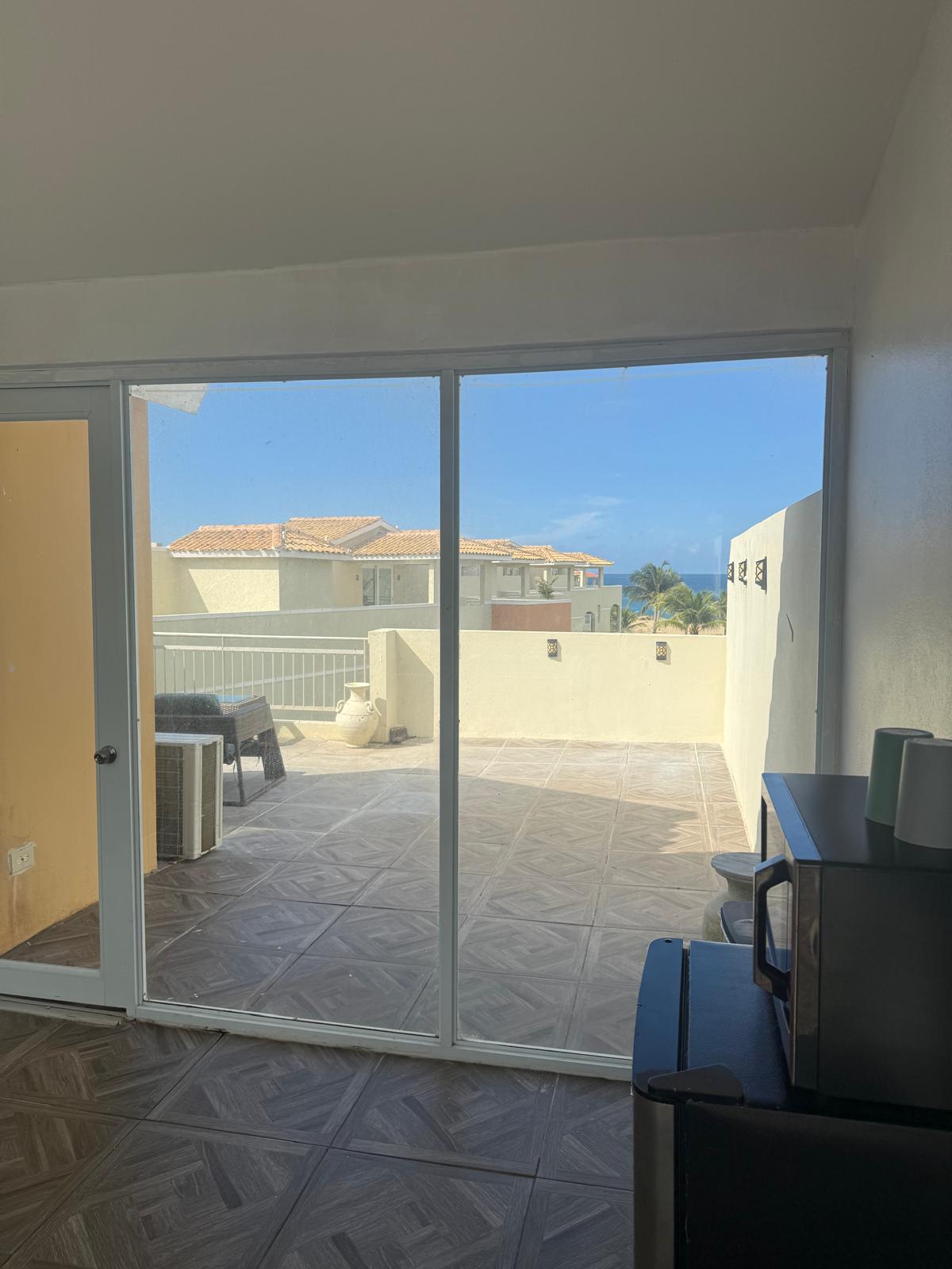 View from inside the Studio through sliding glass doors onto the sunny terrace